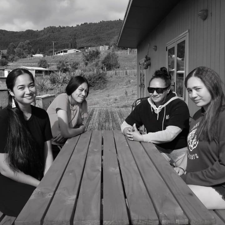 Three Women Staff Seated With Momi Afelin Of Hawaii At Table Outside Manawa Honey Office, Ruatāhuna, Te Urewera, NZ